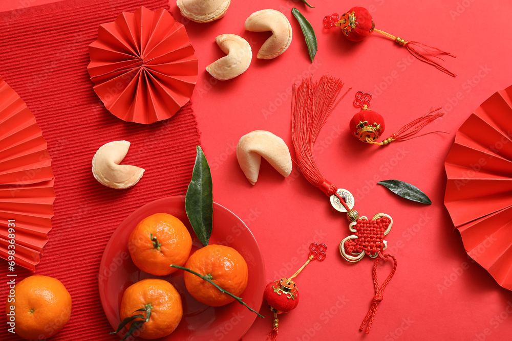 Composition with paper fans, tangerines, fortune cookies and Chinese symbols on red background. New Year celebration Composition with paper fans, tangerines, fortune cookies and Chinese symbols on red background. New Year celebration