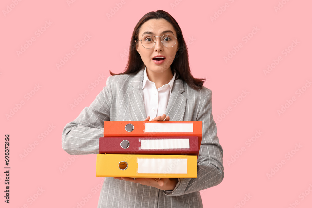 Happy young businesswoman in eyeglasses with document folders on pink background Happy young businesswoman in eyeglasses with document folders on pink background