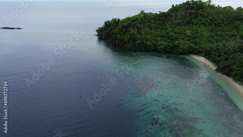 aerial view of the coastline filled with coconut trees. Tropical island with tropical beaches and crystal ocean. Dionumo island, gorontalo, Indonesia photo