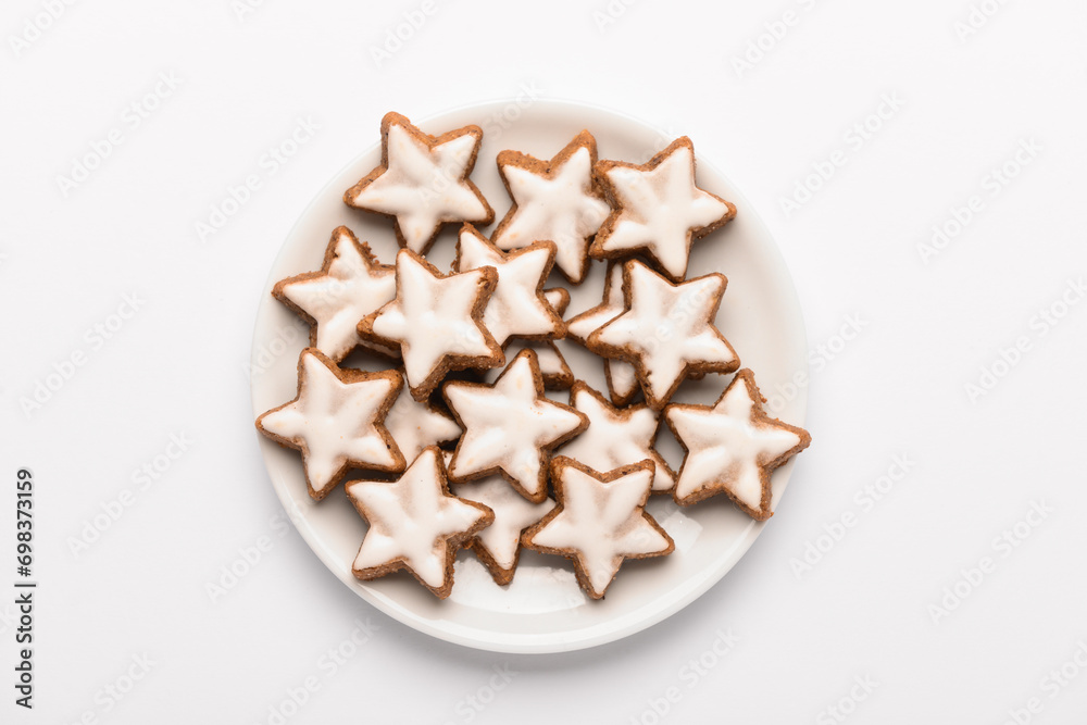 Plate with star-shaped gingerbread cookies on white background