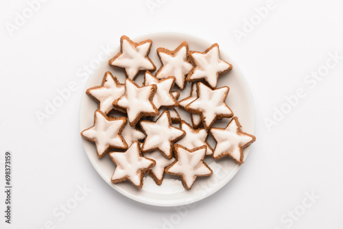 Plate with star-shaped gingerbread cookies on white background