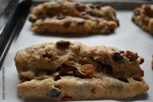 Bread dough with dried fruit mix on a baking tray. Stollen shape.
