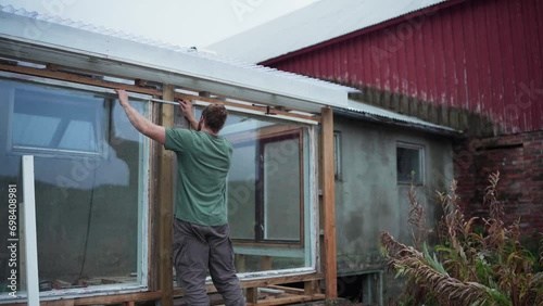 Wallpaper Mural Builder With Foldable Meter Stick Is Measuring Clearance Of Greenhouse Windows. Medium Shot Torontodigital.ca