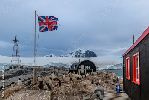 British flag and Gentoo Penguins are seen outside Port Lockroy, the British Antarctic base, Port Lockroy, Wiencke Island in the Palmer Archipelago, Antarctica photo
