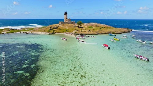 Aerial drone view of a lighthouse on Ile aux Fouquets, Ile au Phare, Bois des Amourettes, Mauritius. Flying over touristic attraction of historic lighthouse fortress on small tropical island. photo