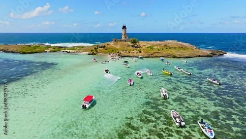 Aerial drone view of a lighthouse on Ile aux Fouquets, Ile au Phare, Bois des Amourettes, Mauritius. Flying over touristic attraction of historic lighthouse fortress on small tropical island. photo