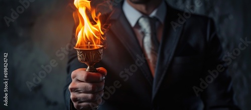 Businessman's arm lifting torch. © AkuAku