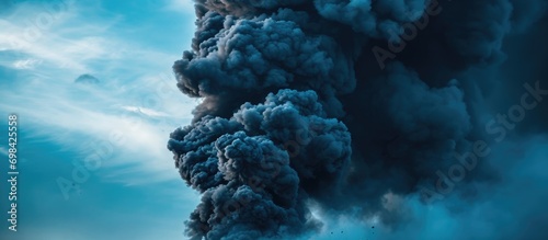 Black smoke exploding in the blue sky. photo