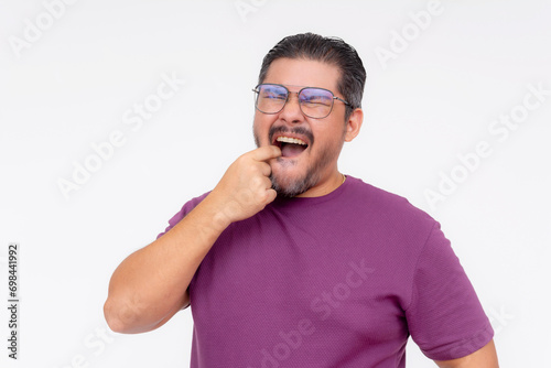 A middle aged man winces in pain from an aching lower molar. Attempting to gauge and touch the tender tooth. Isolated on a white background.