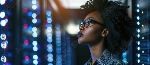 Black woman IT admin diagnosing server performance in secure data storage. photo