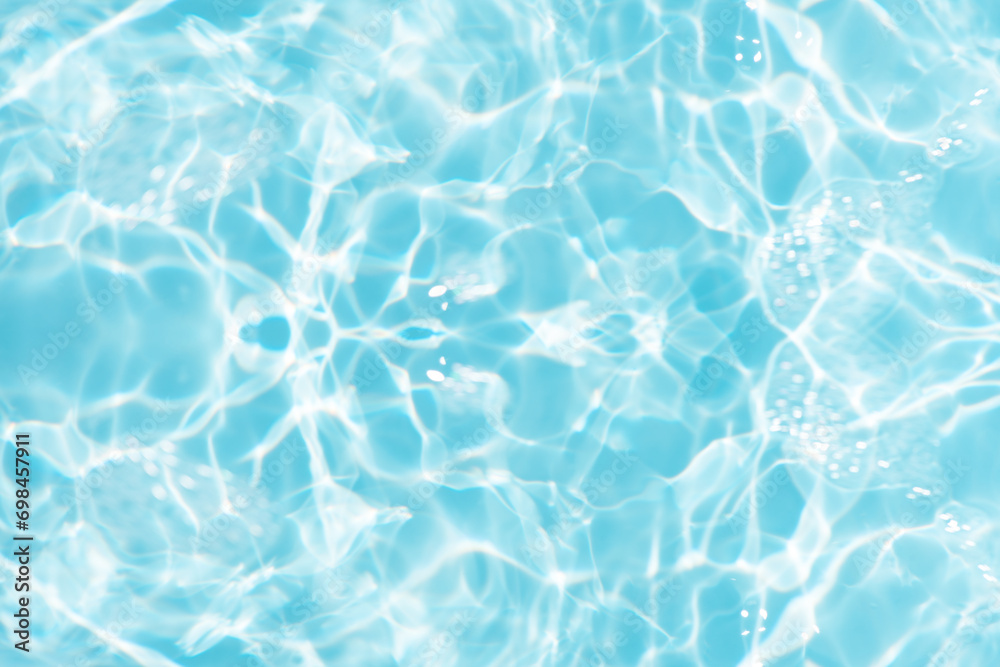 Bluewater waves on the surface ripples blurred. Defocus blurred transparent blue colored clear calm water surface texture with splash and bubbles. Water waves with shining pattern texture background. Bluewater waves on the surface ripples blurred. Defocus blurred transparent blue colored clear calm water surface texture with splash and bubbles. Water waves with shining pattern texture background.