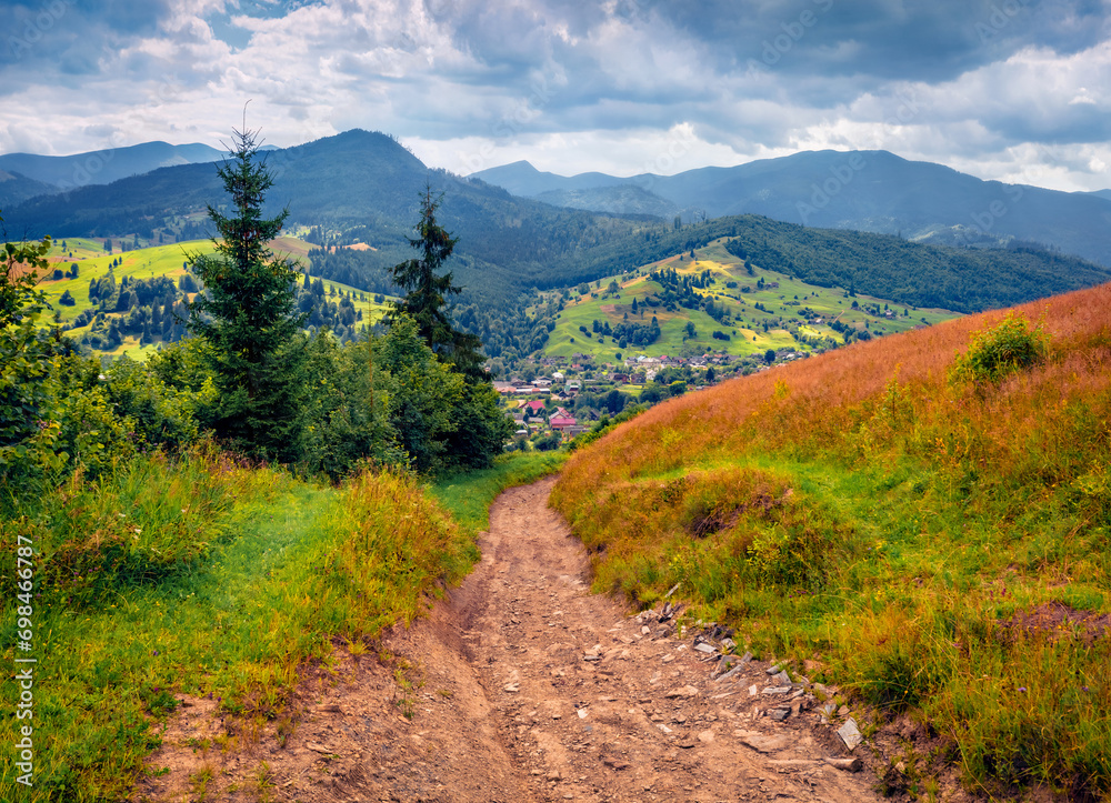 Abandoned country road in the mountain countryside. Gloomy summer view of Carpathian mountains, Ukraine. Wonderful evening scene of mountain village spreads on the mountain hills. Abandoned country road in the mountain countryside. Gloomy summer view of Carpathian mountains, Ukraine. Wonderful evening scene of mountain village spreads on the mountain hills.