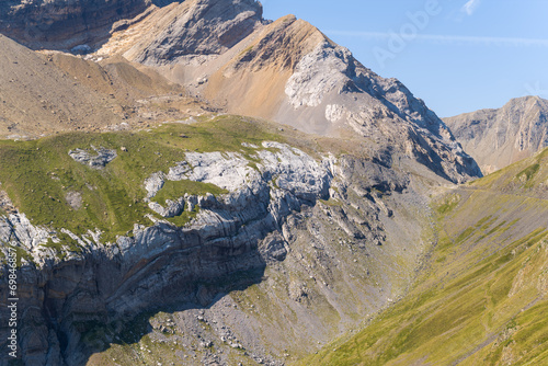 The Mountains around Gavarnie Gedre in the arid green countryside , Europe, France, Occitanie, Hautes-Pyrenees, in summer on a sunny day. photo