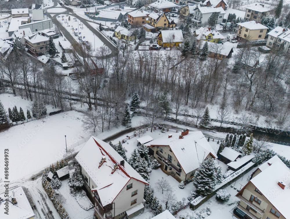 Drone shot of a small town named Limanowa in mountains in Poland covered with fog and snow