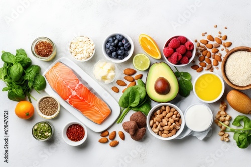 Nutrient-rich meal preparation scene. Overhead shot featuring an array of ingredients—fish steak, mixed berries, vibrant species, nuts, greenery, fresh fruits—arranged on white surface. Generated AI
