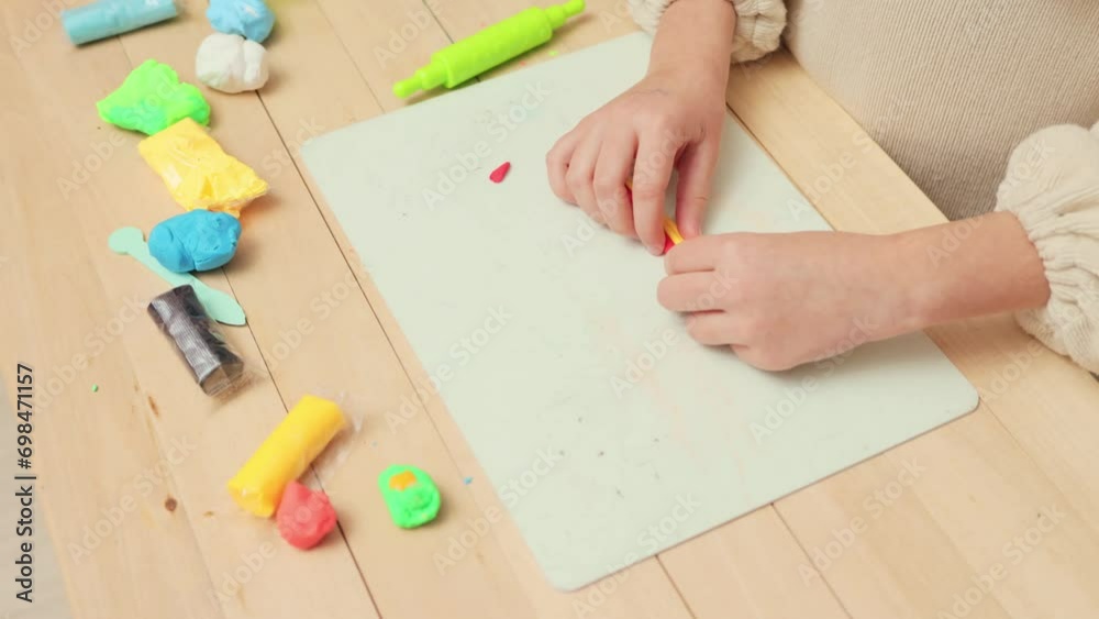 Crafty kids at work. Happy molding moments. Modern educational play. Development through play. Unrecognizable little girl playing with colorful pieces of plasticine Crafty kids at work. Happy molding moments. Modern educational play. Development through play. Unrecognizable little girl playing with colorful pieces of plasticine