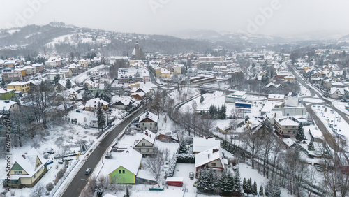 Drone shot of a small town named Limanowa in mountains in Poland covered with fog and snow