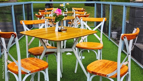 Wooden table and chairs in a summer cafe on the green grass