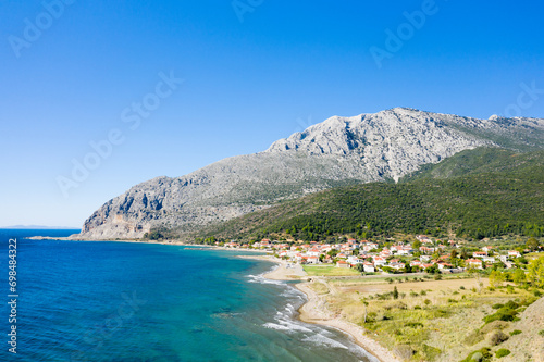 The town on the rocky coast in the middle of green countryside , Europe, Greece, Aetolia Acarnania, Kato Vasiliki towards Patras, by the Ionian Sea, in summer on a sunny day. photo