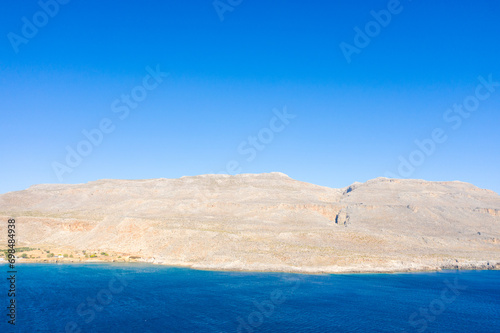 The barren rocky coast and mountains   in Europe  Greece  Crete  towards Sitia  By the Mediterranean sea  in summer  on a sunny day.