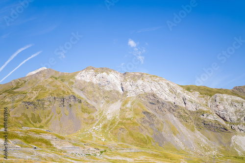 The Mountains around Gavarnie Gedre in the arid green countryside , Europe, France, Occitanie, Hautes-Pyrenees, in summer on a sunny day. photo