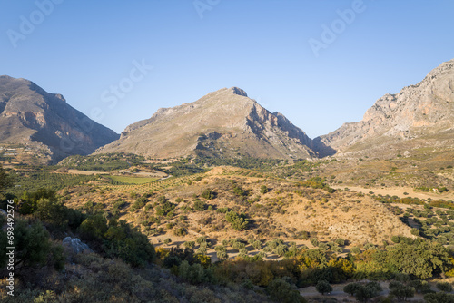 The arid and rocky mountains in the middle of the countryside , in Europe, Greece, Crete, towards Preveli, By the Mediterranean Sea, in summer, on a sunny day.