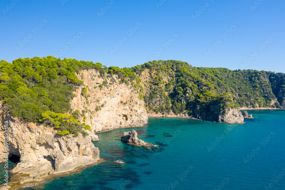 The rocky and green coast, in Europe, in Greece, in Epirus, towards Igoumenitsa, by the Ionian Sea, in summer, on a sunny day.