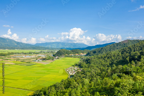 The traditional villages in the middle of the green and yellow rice fields in the valley  Asia  Vietnam  Tonkin  Dien Bien Phu  in summer  on a sunny day.