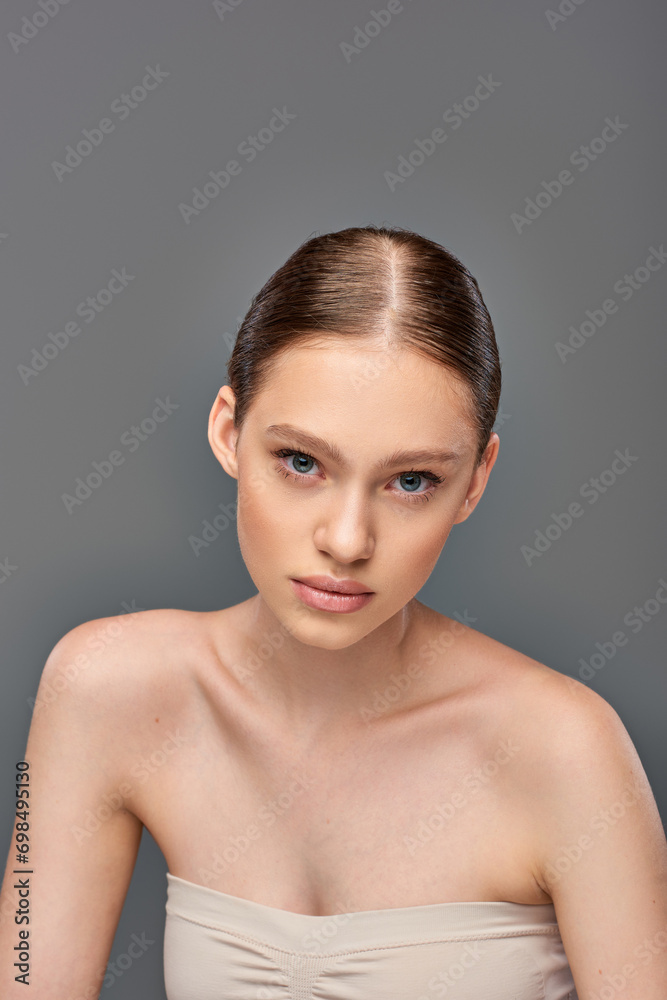 portrait of beautiful young woman with perfect skin looking at camera on grey background, youth portrait of beautiful young woman with perfect skin looking at camera on grey background, youth