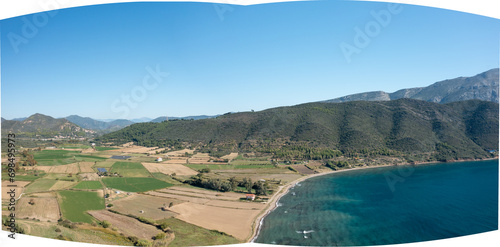 The arid rocky coast and its green countryside, in Europe, in Greece, in Aetolia Acarnania, towards Patras, by the Ionian Sea, in summer, on a sunny day. photo