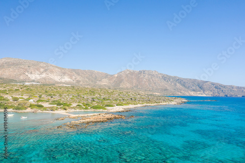 The rocky coast and its arid mountains , in Europe, Greece, Crete, Elafonisi, By the Mediterranean Sea, in summer, on a sunny day. © Florent