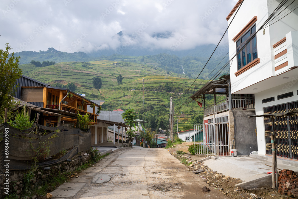 The traditional village with green and yellow rice fields in the green mountains, Asia, Vietnam, Tonkin, Sapa, towards Lao Cai, in summer, on a cloudy day. The traditional village with green and yellow rice fields in the green mountains, Asia, Vietnam, Tonkin, Sapa, towards Lao Cai, in summer, on a cloudy day.