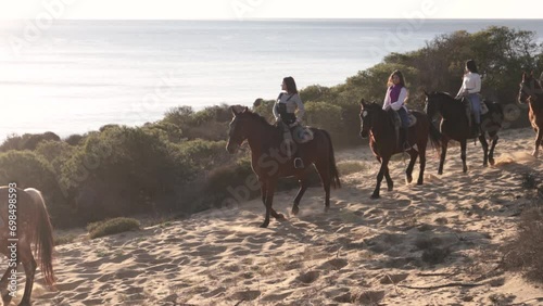 young women riding horses near the sea