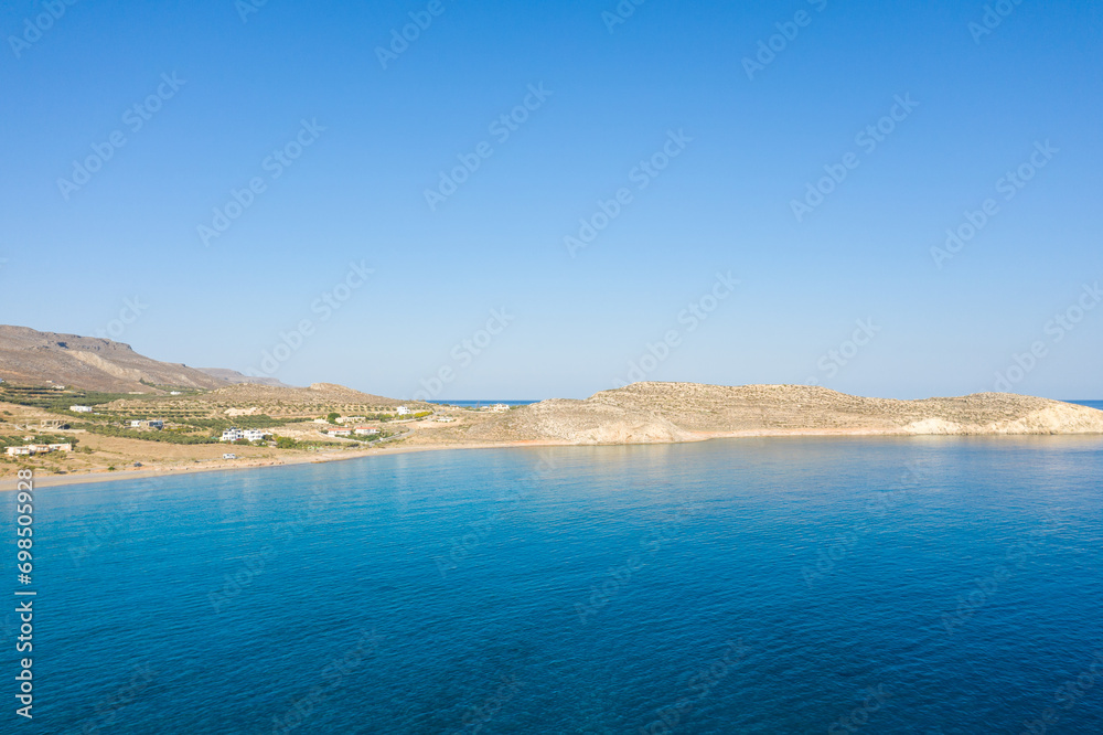 The sandy beach of Ambelou at the foot of the mountains , in Europe, Greece, Crete, towards Zakros, By the Mediterranean Sea, in summer, on a sunny day.
