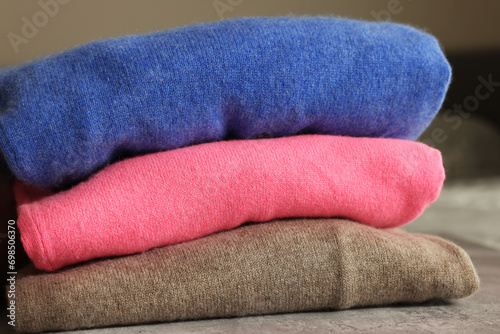 Folded color sweaters on gray table, closeup © New Africa