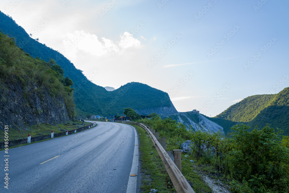 An asphalt road in the middle of the countryside and mountains, in Asia, in Vietnam, in Tonkin, towards Hanoi, in Mai Chau, in summer, on a sunny day.