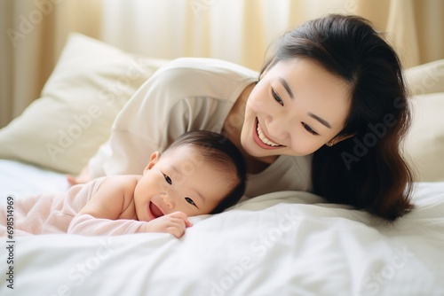 family and motherhood concept - happy smiling young asian mother with little baby at home
