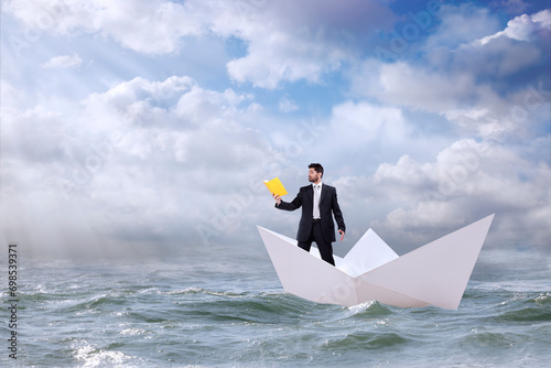 Businessman navigates the open sea atop a paper boat, absorbed in a book.