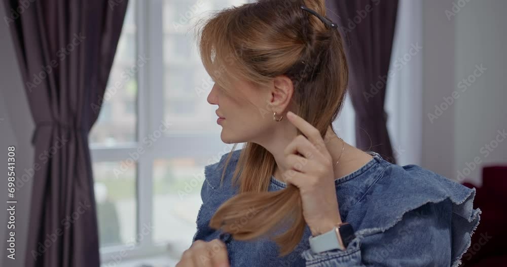 Blonde girl parts her hair for styling Blonde girl parts her hair for styling