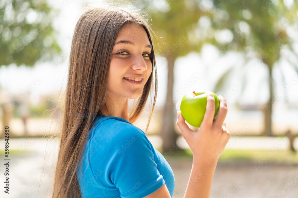 Teenager girl at outdoors eating an apple Teenager girl at outdoors eating an apple