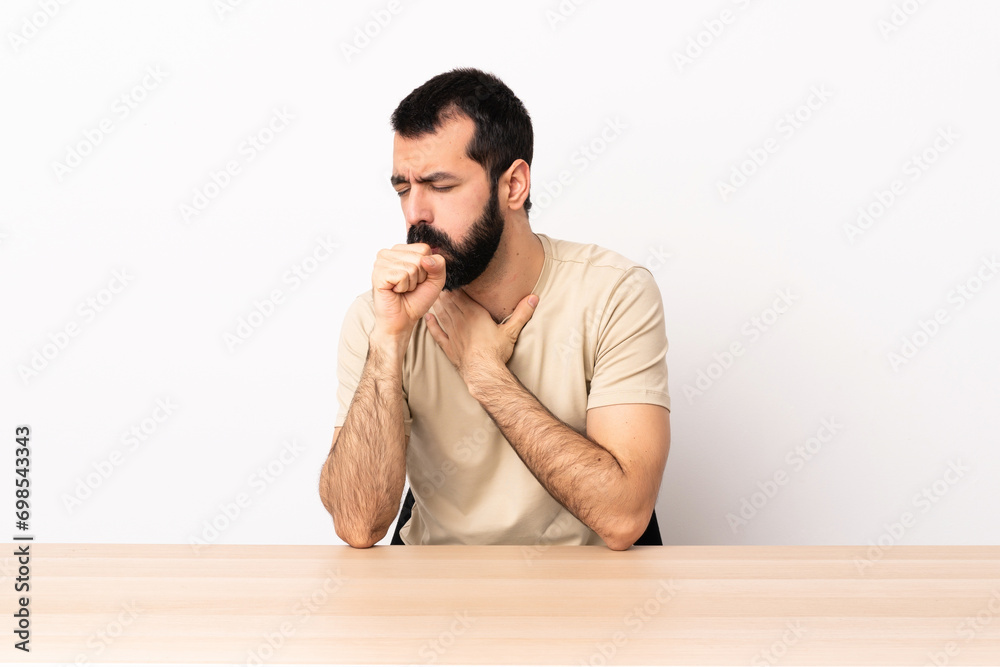Caucasian man with beard in a table coughing a lot. Caucasian man with beard in a table coughing a lot.