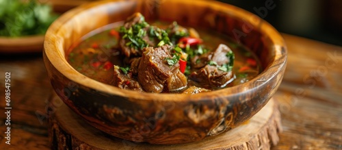 Homemade lamb paya soup ready to eat in a wooden bowl. photo