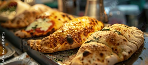 Traditional Neapolitan dishes sold at a street food stand include fried calzone, pagnottiello, and pizza. photo