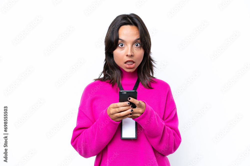 Young hispanic woman with ID card isolated on white background surprised and sending a message Young hispanic woman with ID card isolated on white background surprised and sending a message