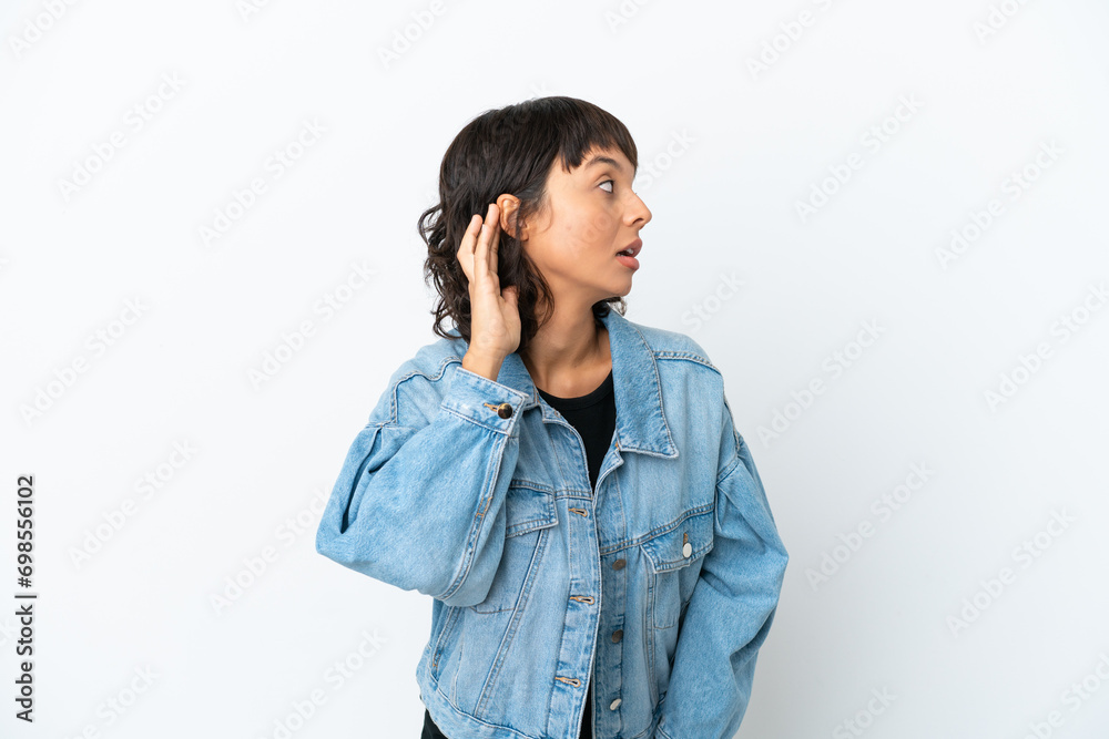Young mixed race woman isolated on white background listening to something by putting hand on the ear Young mixed race woman isolated on white background listening to something by putting hand on the ear