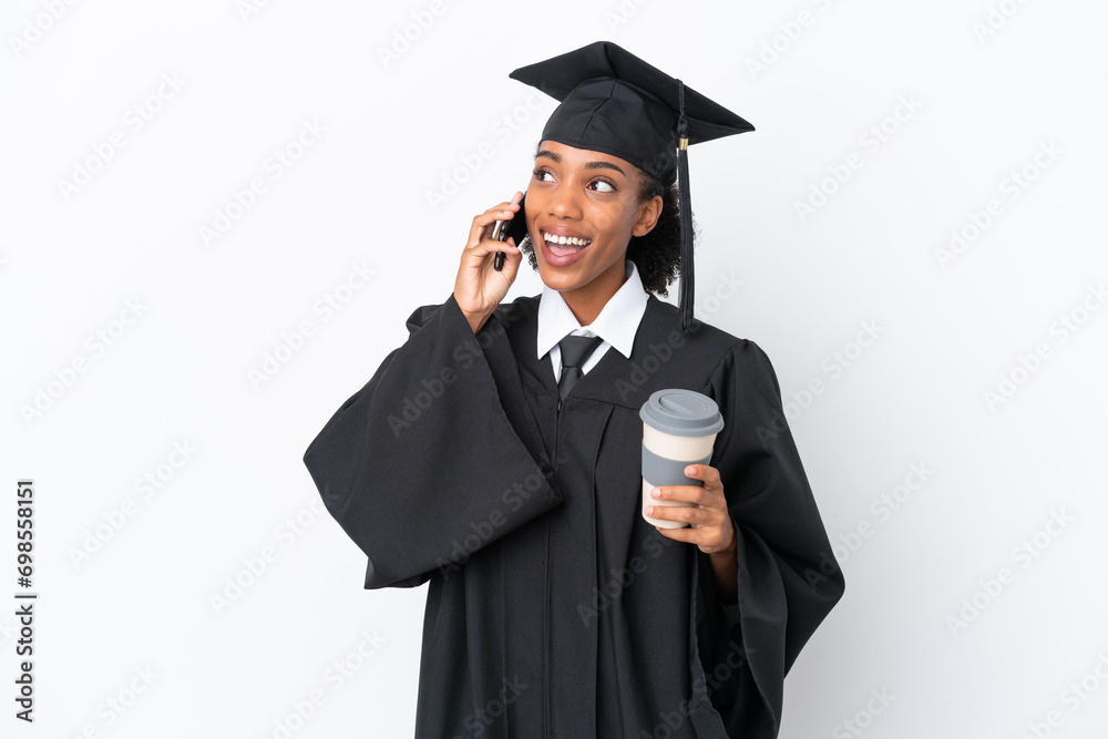Young university graduate African American woman isolated on white background holding coffee to take away and a mobile Young university graduate African American woman isolated on white background holding coffee to take away and a mobile