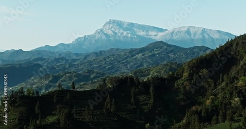 Aerial View of the Golden Summit of Mount Emei from small spring Village in the tea field mountain at Sichuan China photo