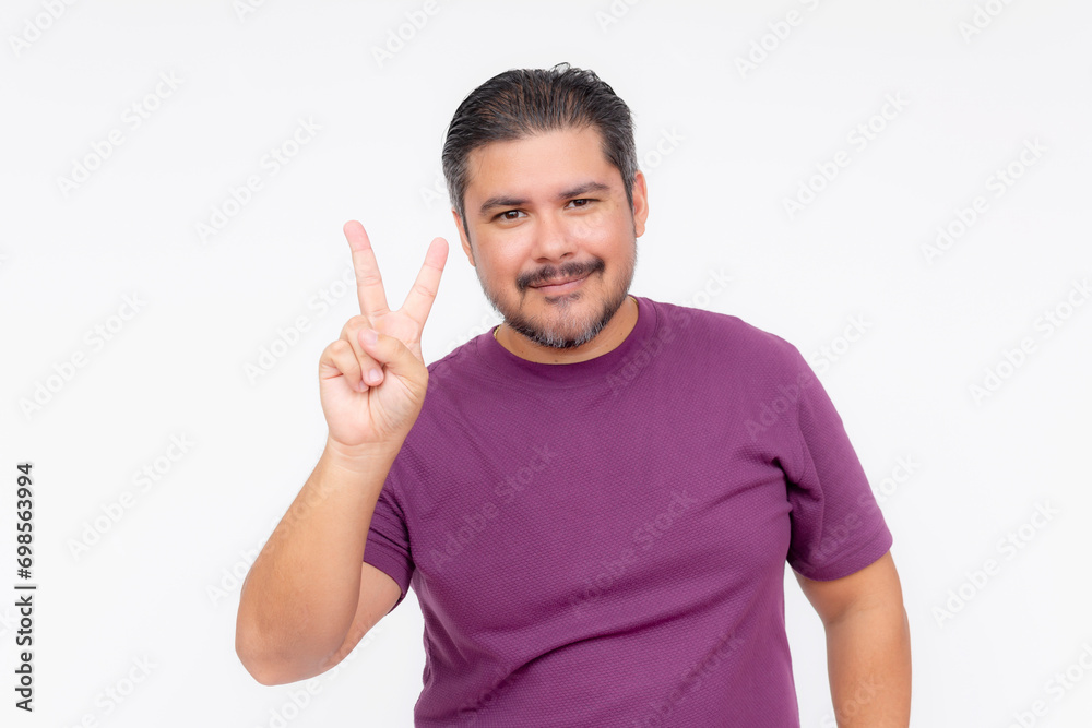 Portrait of a chubby bearded guy making the peace sign with one hand. Wearing a purple waffle shirt. Half body photo isolated on white background. Portrait of a chubby bearded guy making the peace sign with one hand. Wearing a purple waffle shirt. Half body photo isolated on white background.