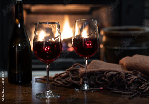 Two glasses of wine with fireplace in background