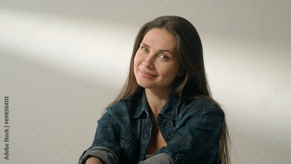 Portrait of appealing female model in friendly mood. Brunette woman in casual on white background in studio smiling cutely natural expression. Portrait of appealing female model in friendly mood. Brunette woman in casual on white background in studio smiling cutely natural expression.